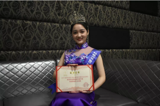 刘涵娜手持《海华都市报》、《费城生活攻略》证书