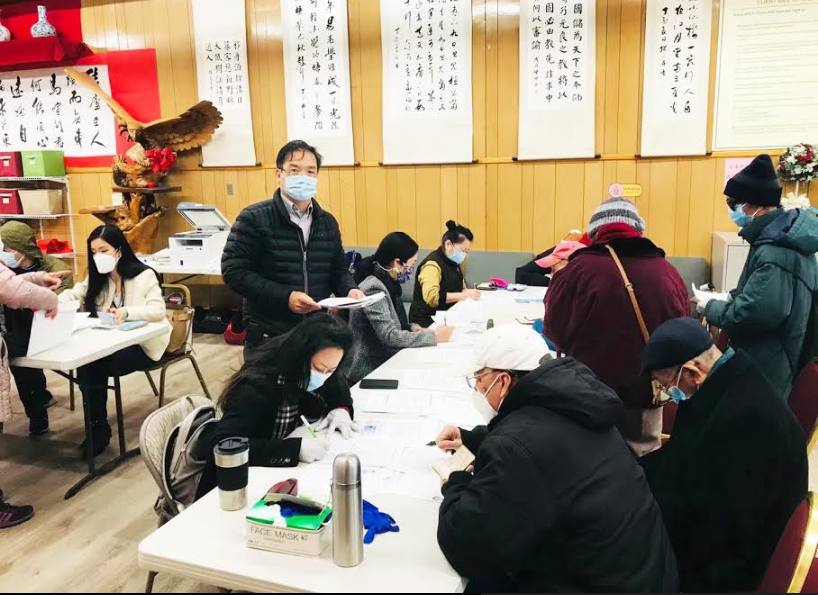 办理健在证现场，工作人员在忙碌的检查资料