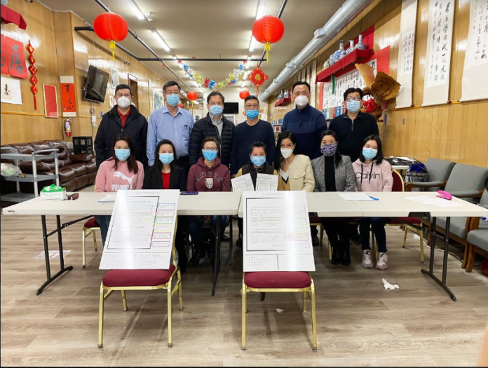 协助办理健在证的华埠侨领、义工及留学生 志愿者们合影。后排左至右：吴日强、黄伟星、 张天晨、林明华、王建明、梁鸿生，前排左2 至6：姚红、任美清、叶慧民、沈慧石、王小玉